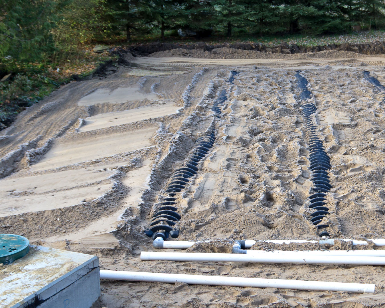 Construction site view of a septic drain field and raised bed sand filled weeping bed.