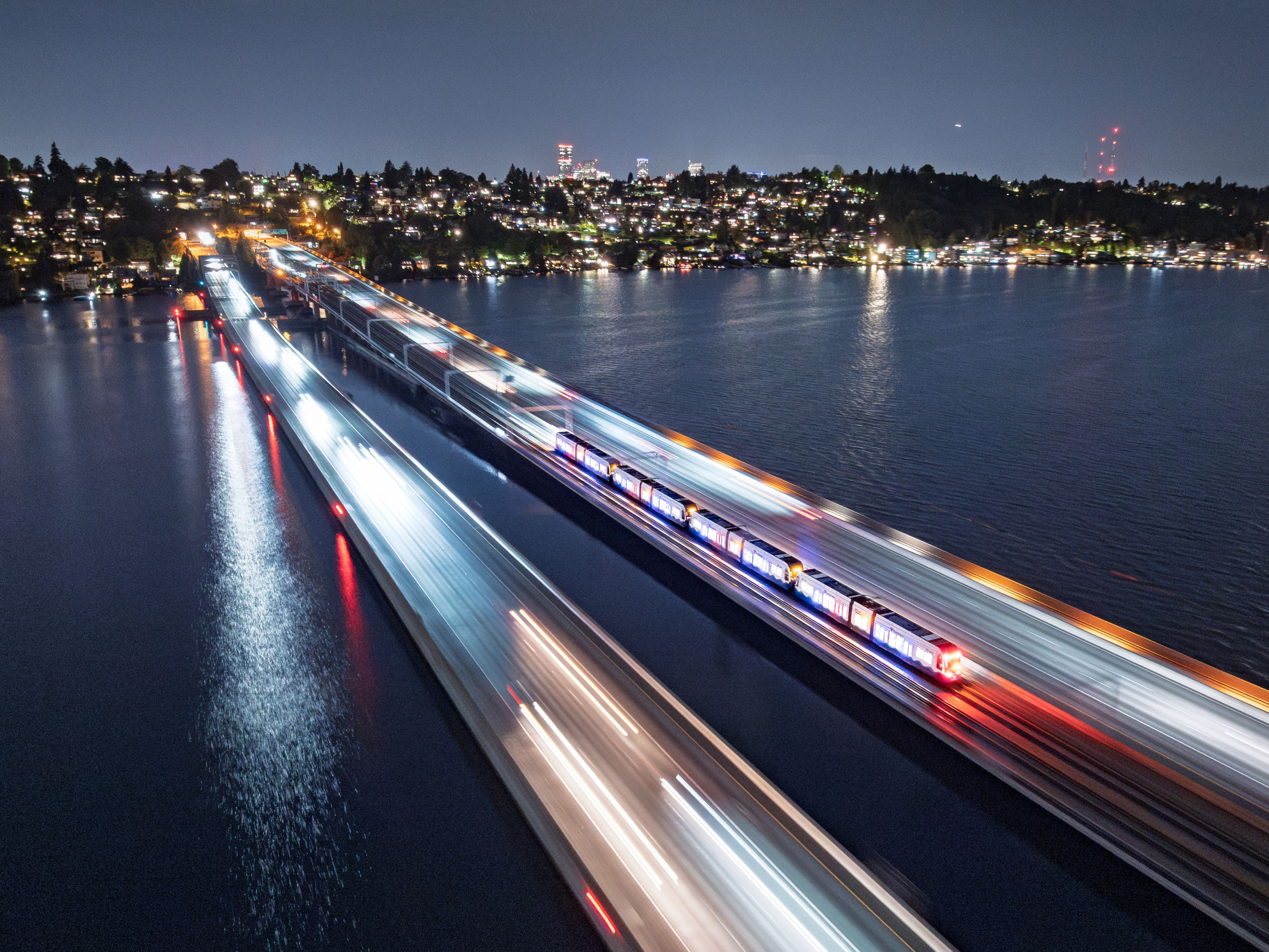 The world’s first light rail system crossing a floating bridge over Lake Washington in Seattle, WA at night.